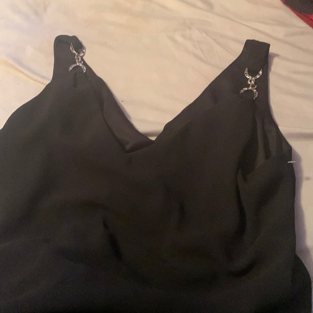 It’s black and has sliver chained tank top look on the top. It’s a 12 and flowy.